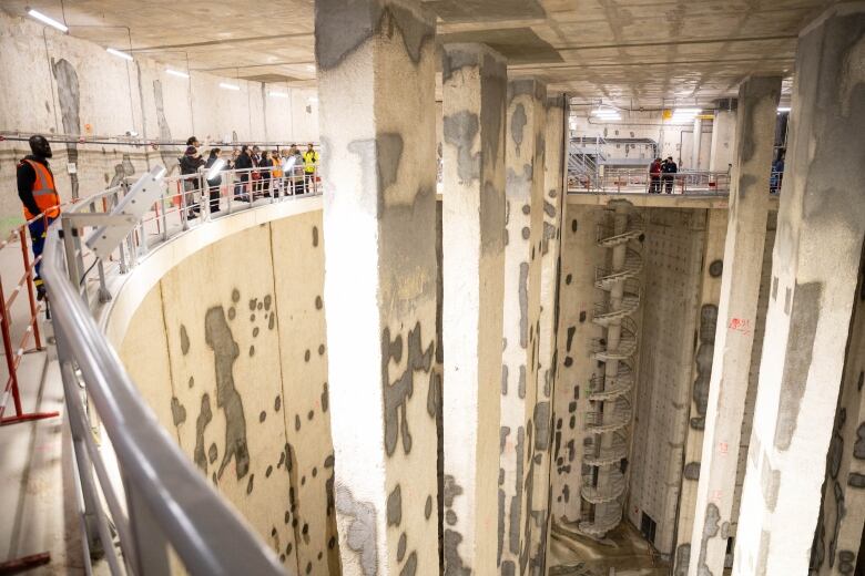 People looking at a water storage basin.