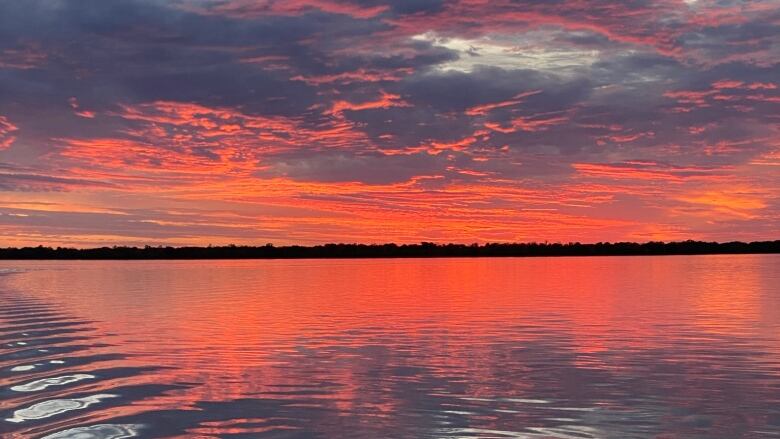 Surface waters ripple on a lake at sunset.