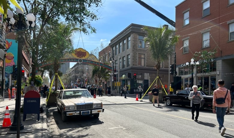 Old cars on street and sign above street