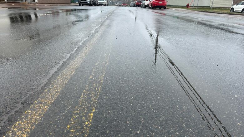 Road lines faded on wet pavement.