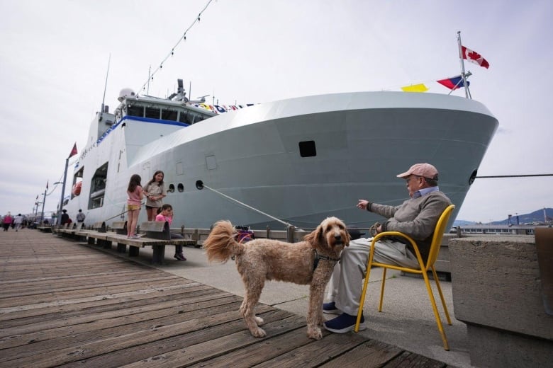 A man and a dog beside a boat.