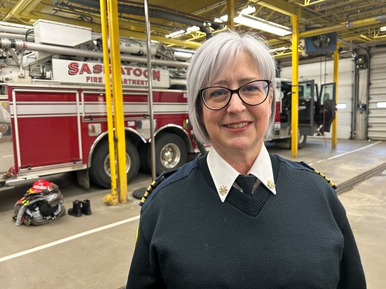 A woman standing in a fire hall.