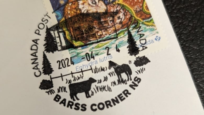 A postmark shows a cow, a horse, Christmas trees and a small post office building.