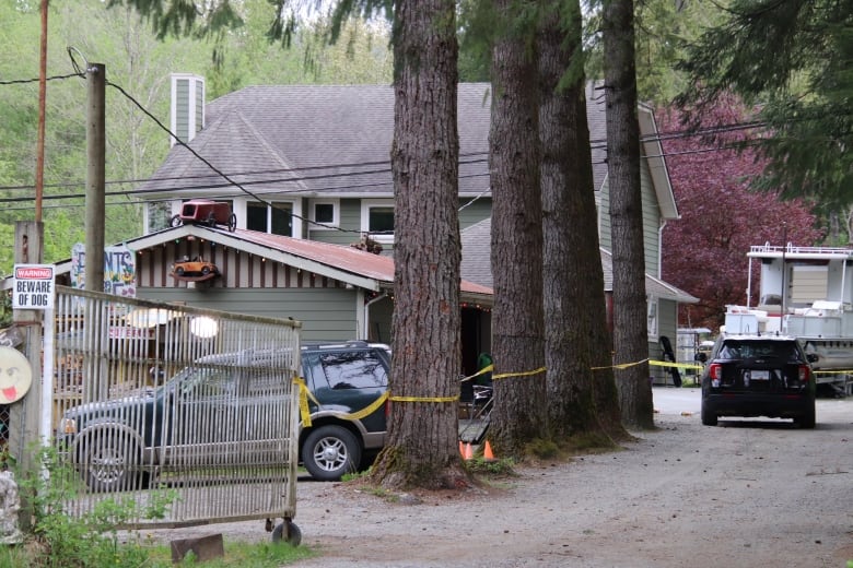 A large rural home with crime tape around it.