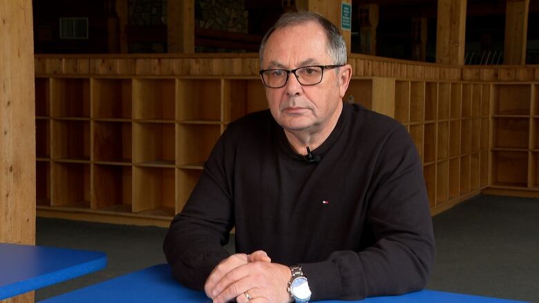 A middle aged man sitting at a table.