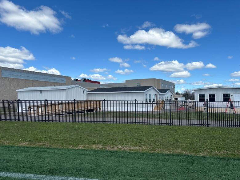 A picture showing four external house like units in front of a school building.