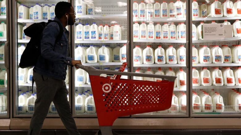 A shopper walks past the milk and dairy display case at a Target store in New York City.