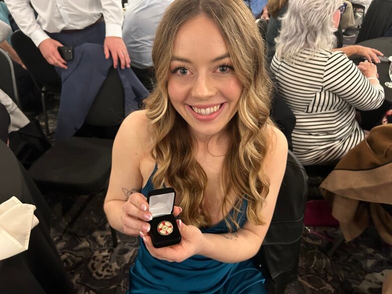 Young woman showing nursing pin.