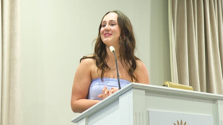 Woman standing at podium.