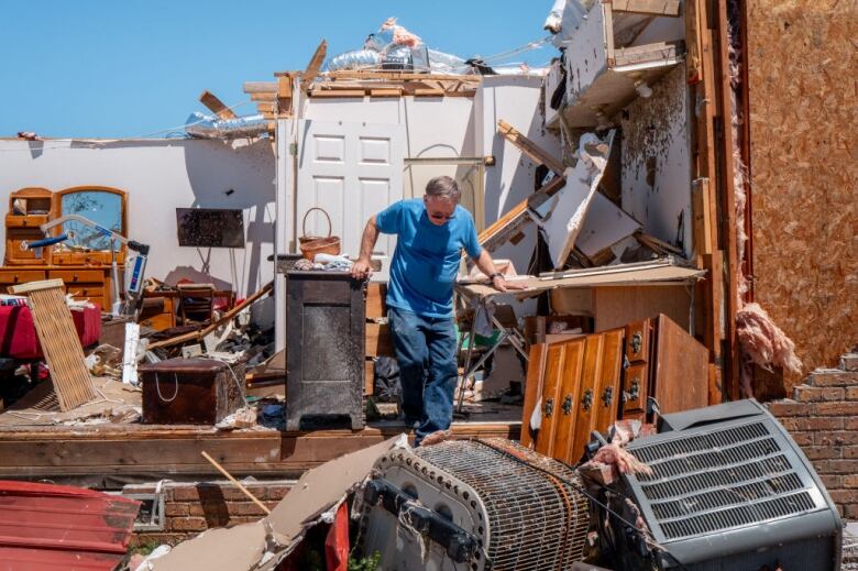 Tommy Lang works to recover items from his father's home after it was struck by a tornado on May 07, 2024 in Barnsdall, Okla.