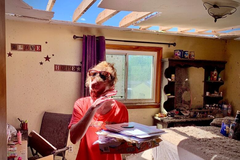 Brenda Pollitt of Greenville, Ohio, is seen removing important papers from her bedroom, after her home was hit by a storm the previous evening.