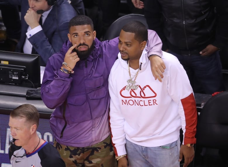 Two men embrace courtside at a basketball game