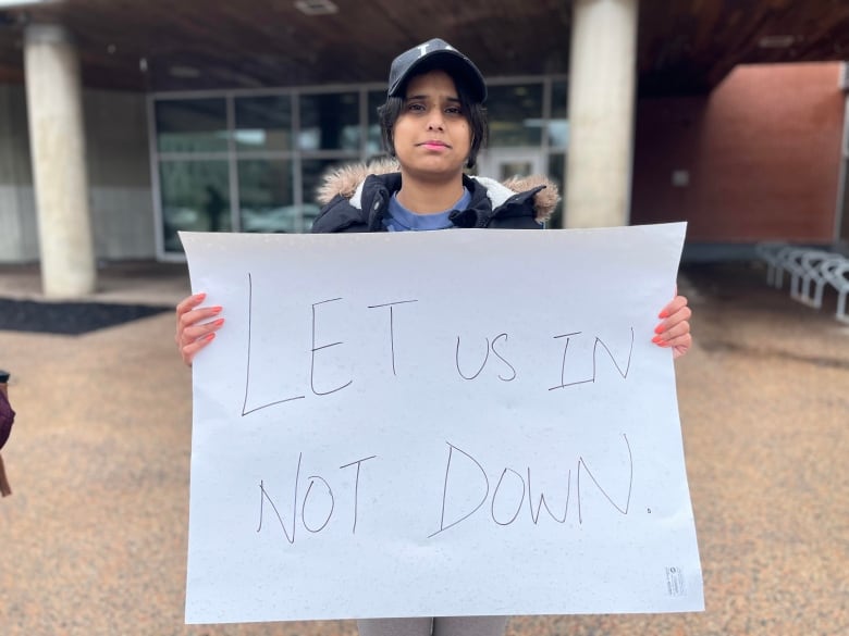 A woman holding a sign that says 