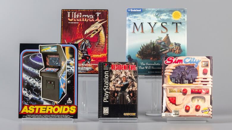 Studio shot of five video games in their boxed packaging.