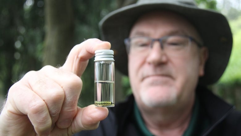 A man holds a vial