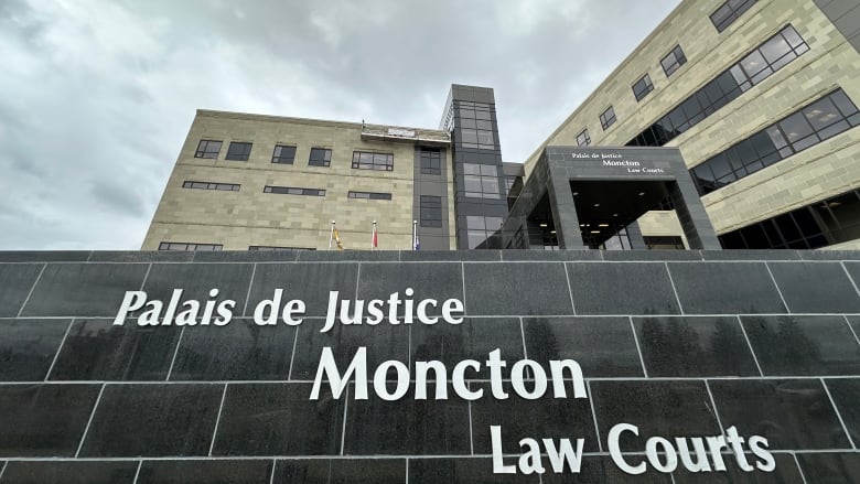 Exterior of a multi-storey stone-clad building with the words 