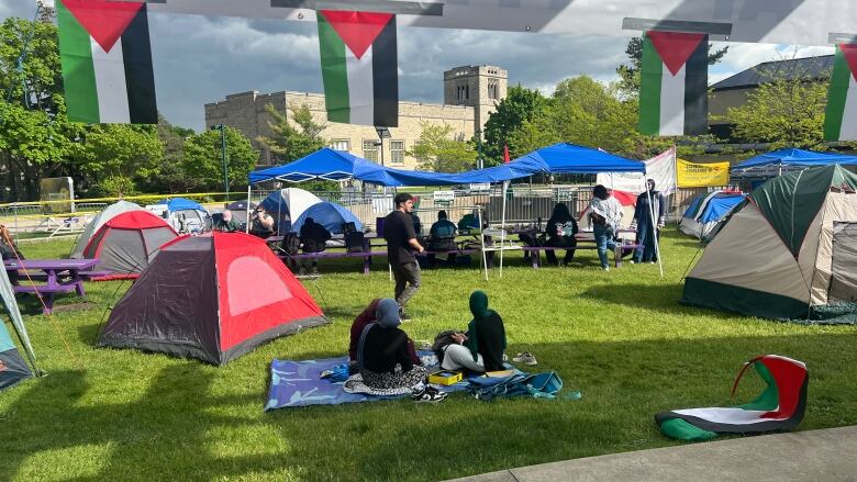 people sit on blankets near tents on grass at Western University