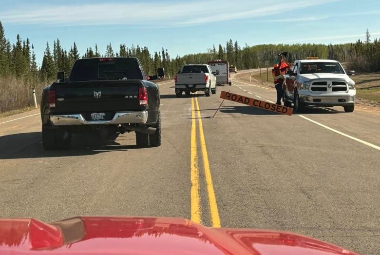 A highway with a road closed sign. 