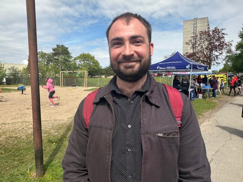 A man stands in a city park. 