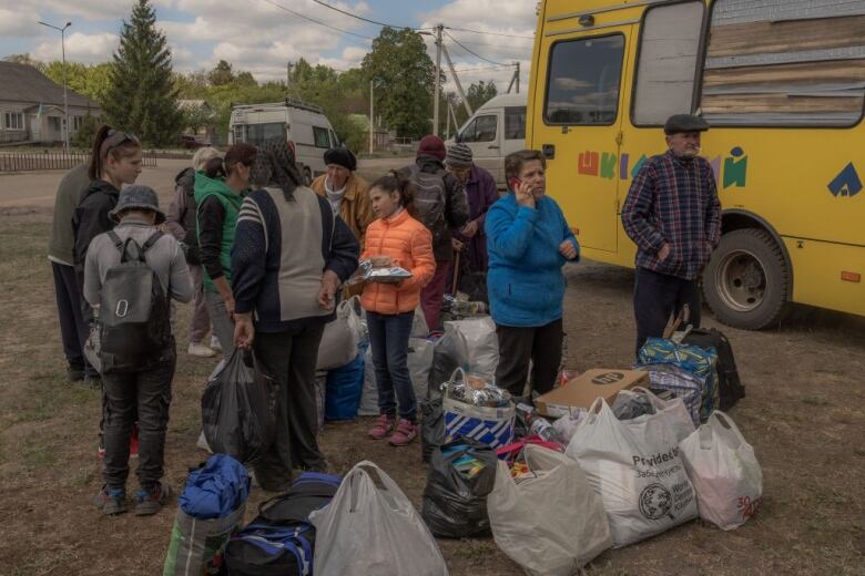 Evacuees stand with their belongings in Kharkiv, Ukraine.