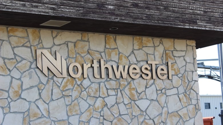 Close up of brown building with brass lettering that says Northwestel.