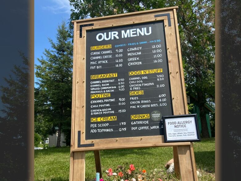 A menu shows a variety of food items for sale outside a food truck.