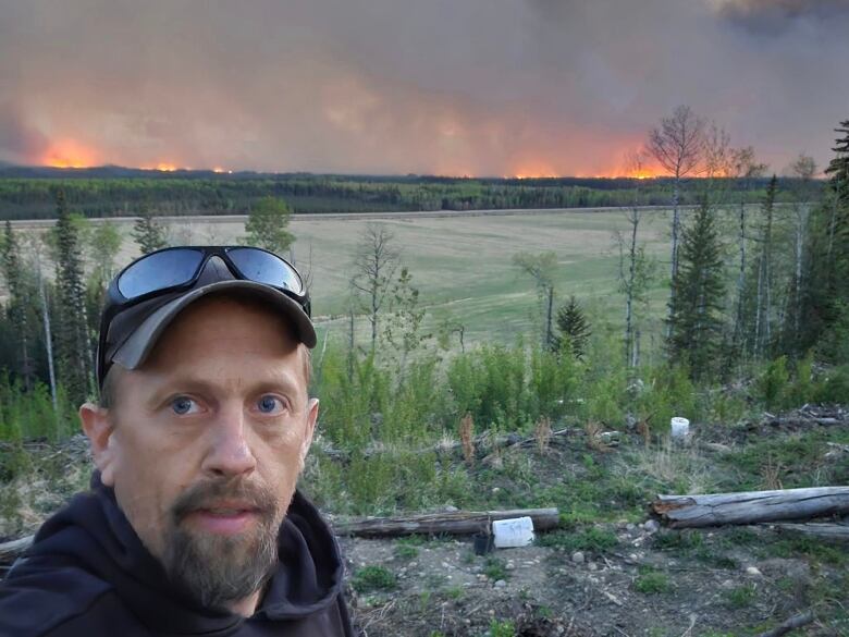 A man with a fire burning behind him.