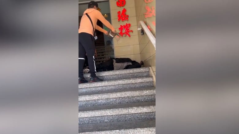 Man pours water on man who is sleeping outside