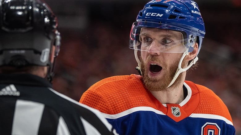 An Oilers player turns to his right to say something to NHL referee during stop in play of a May 12, 2024 Stanley Cup playoff game against the Vancouver Canucks in Edmonton. 