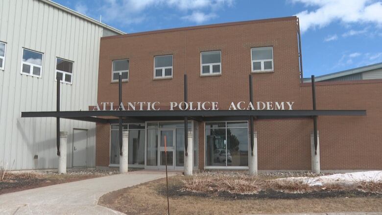 A brown brick building with white lettering that reads 'Atlantic Police Academy.'