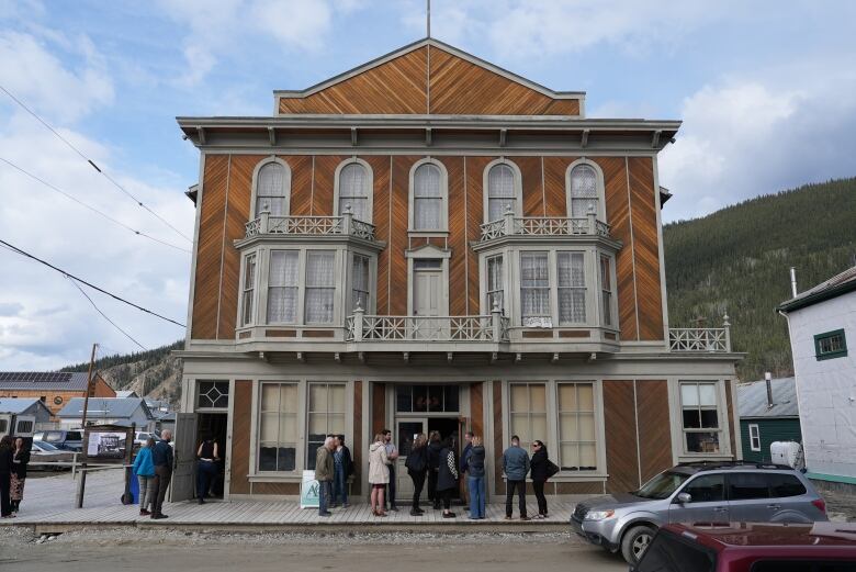 A bunch of people standing outside of an old building.