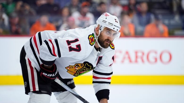 A bearded hockey player wearing a white jersey.