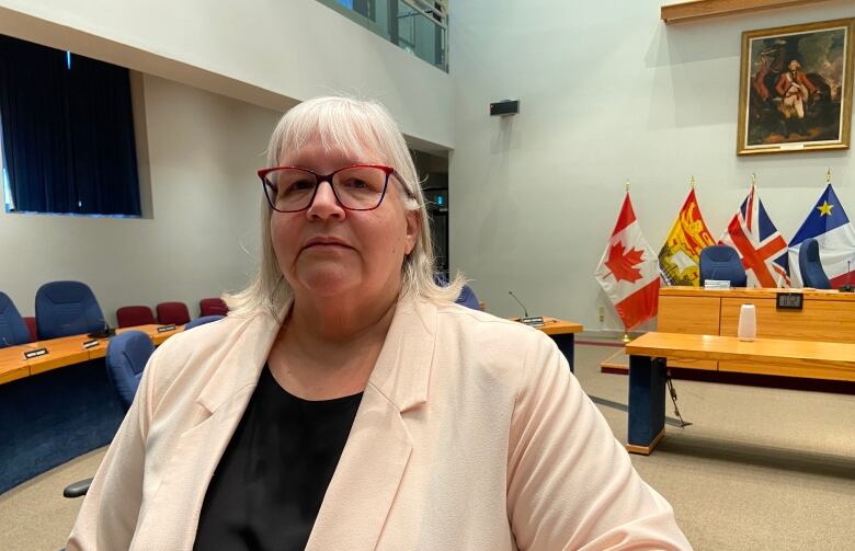 Janet Flowers stands in Fredericton city council chambers.