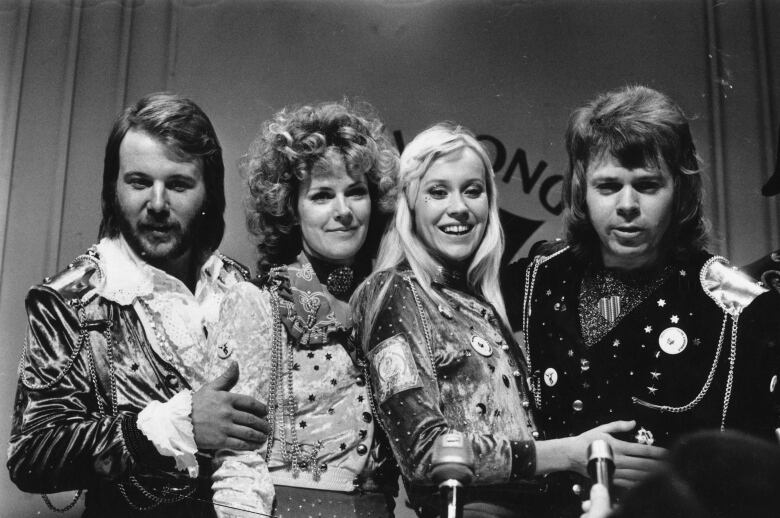 The members of pop group ABBA smile and pose for a photo. 