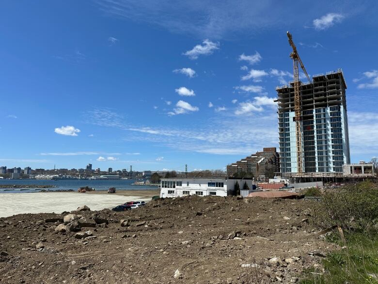 A building under construction is shown next to land and water.