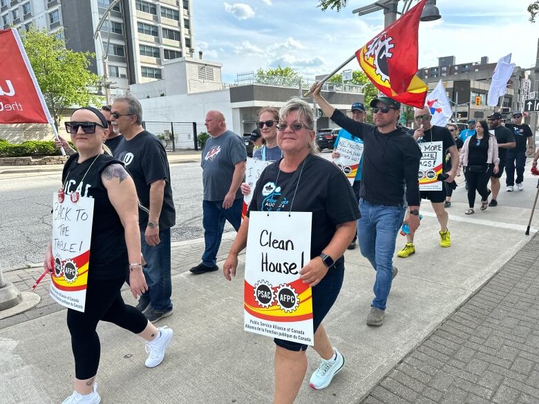 Members of the CIU union carry banners and cowbells while protesting slow progress in contract talks.