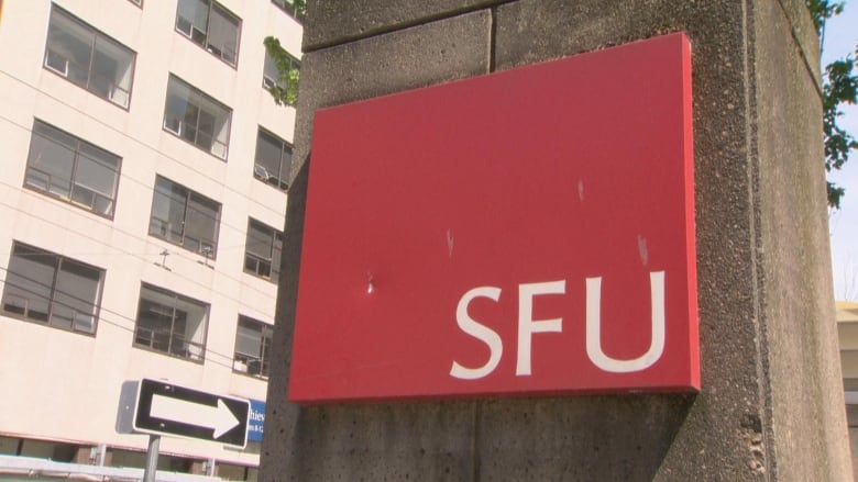 A sign displaying the SFU logo, with the university's initials inside a red block, is erected on a post. 