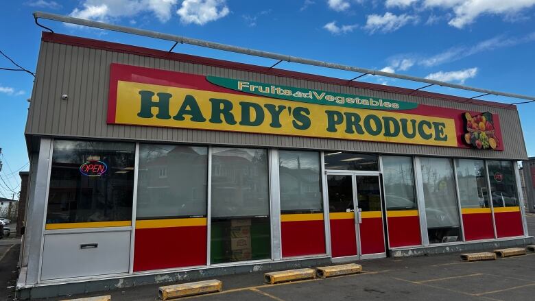 A building with glass windows says Hardy's Produce across the front.