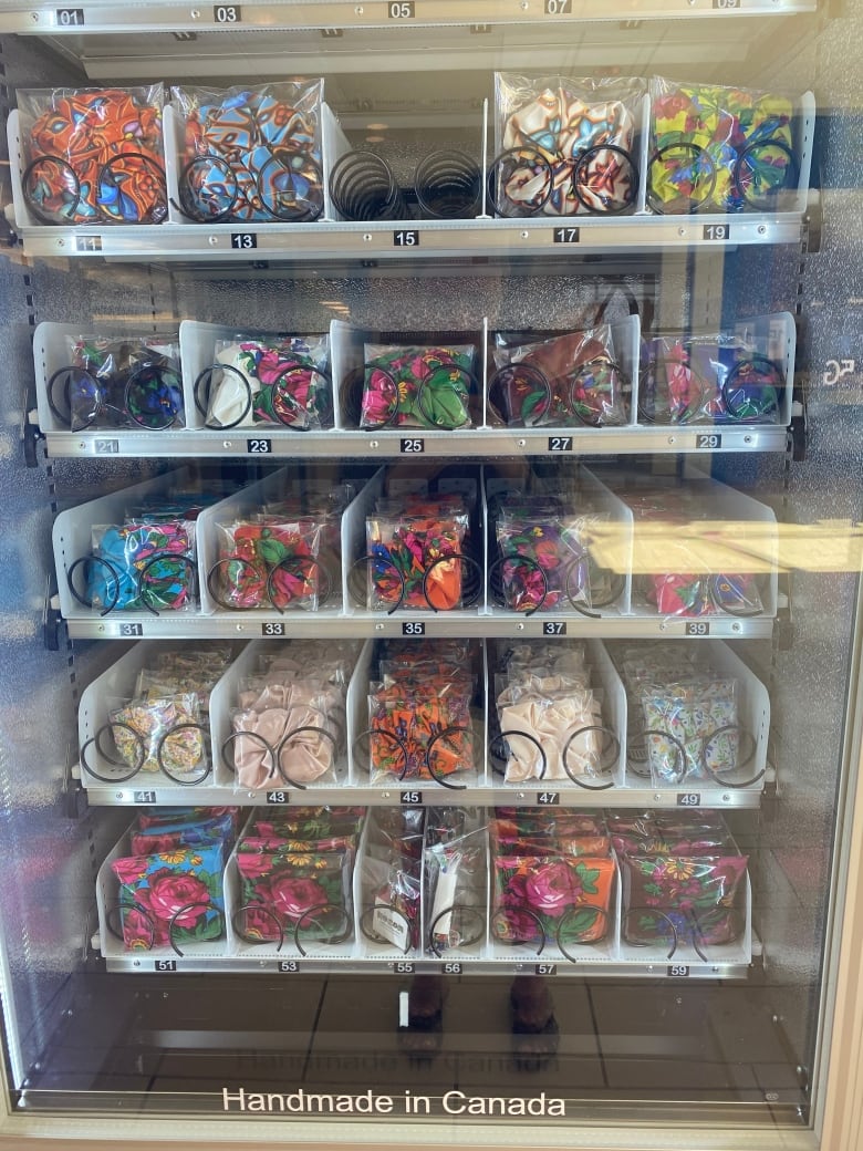 A vending machine is filled with colourful, patterned scrunmchies, scarves, and headbands.