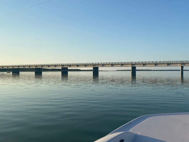 A bridge is seen over glassy lake surface