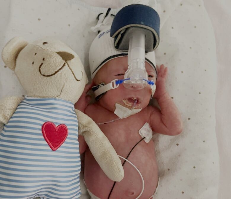 Sutton shortly after being born, next to her first teddy bear.  