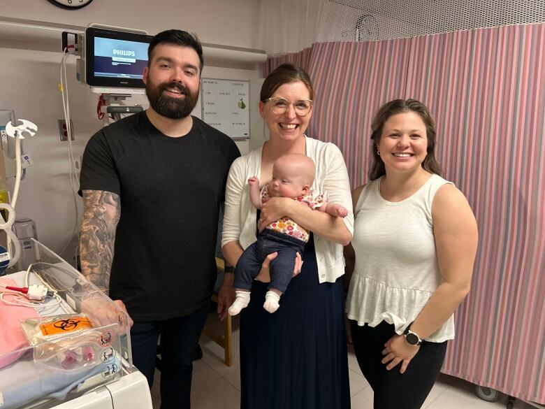 Baby Sutton on a visit to the NICU with her parents and Brown.