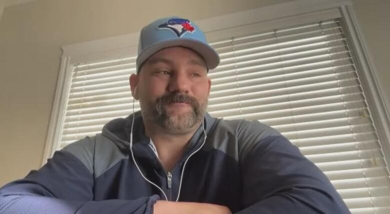 a man with a moustache in a Toronto Blue Jays hat