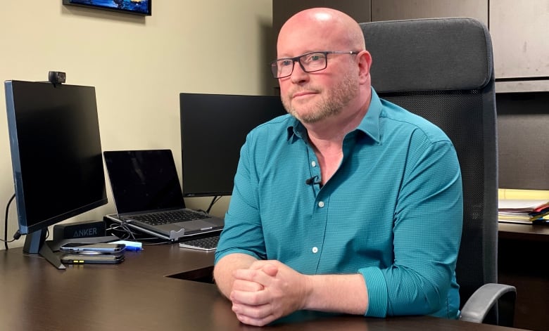 Photo of Scott Andison seated at his desk. 