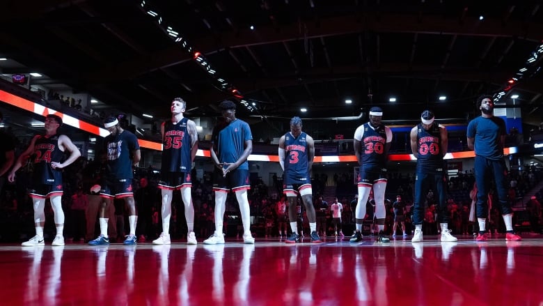 Calgary Surge players stand during the singing of the national anthem before playing the Scarborough Shooting Stars during the CEBL basketball championship final, in Langley, B.C.