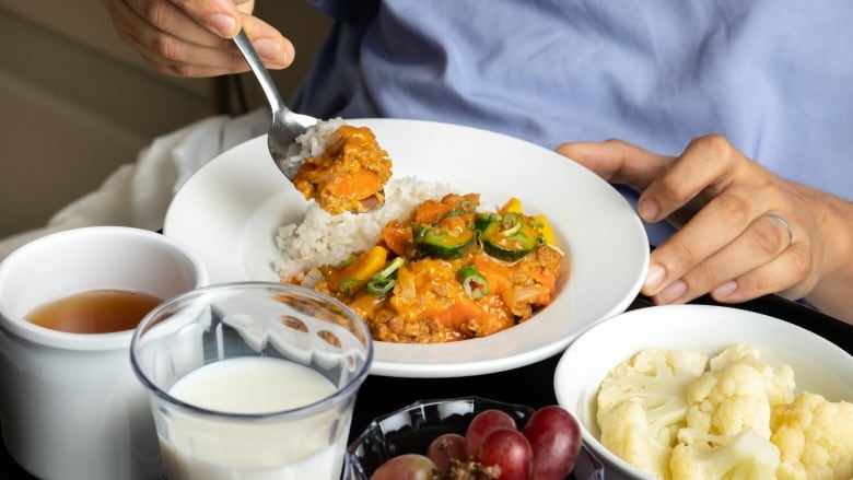 A shot of Korean gochujang bowl, surrounded by bowls of cauliflower and grapes, as well as glasses of milk and coffee.