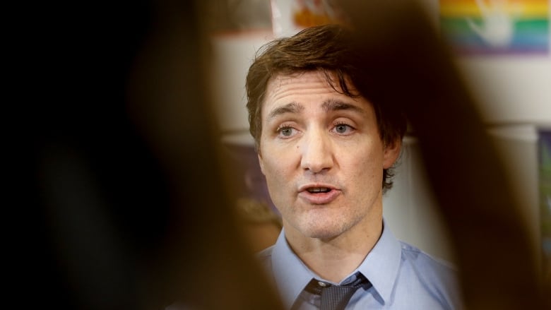 A man speaks in a classroom.