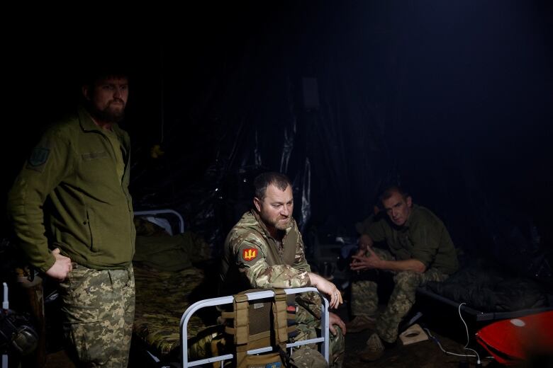 Ukrainian servicemen wait inside a dugout. 