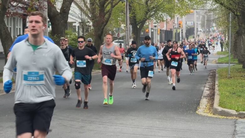 Many people are seen running on a street.