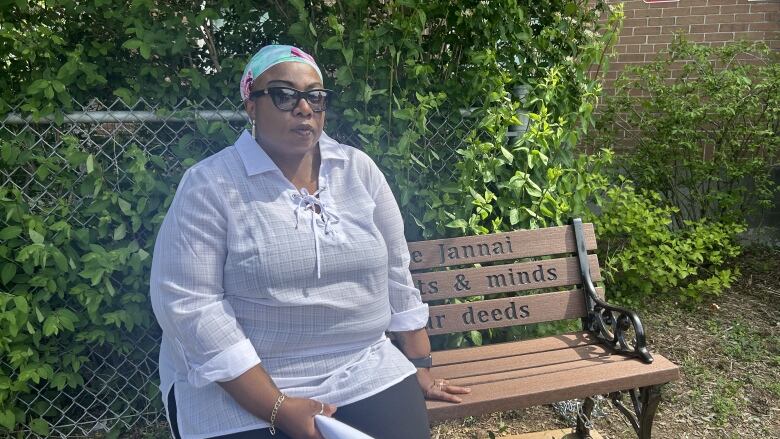 Woman sits on bech outside